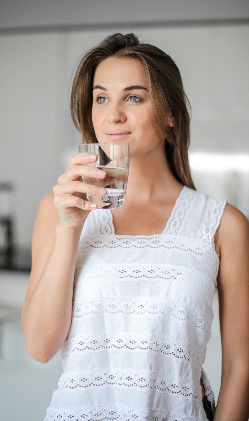 Frau trinkt Wasser aus der Bela Aqua Osmoseanlage